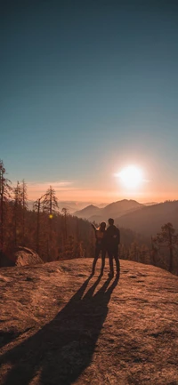 Casal abraçando a natureza ao pôr do sol em uma paisagem de montanha