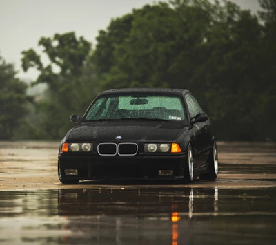 Schwarzer BMW E36 M3 Coupé in regnerischer Umgebung