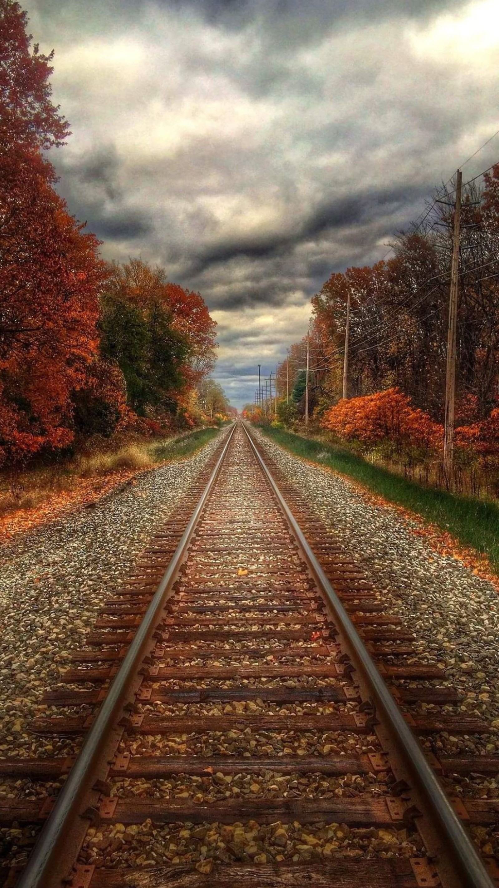 Hay una vía de tren que va por el medio de la carretera (nubes, naturaleza, ferrocarril, piedras, pista)