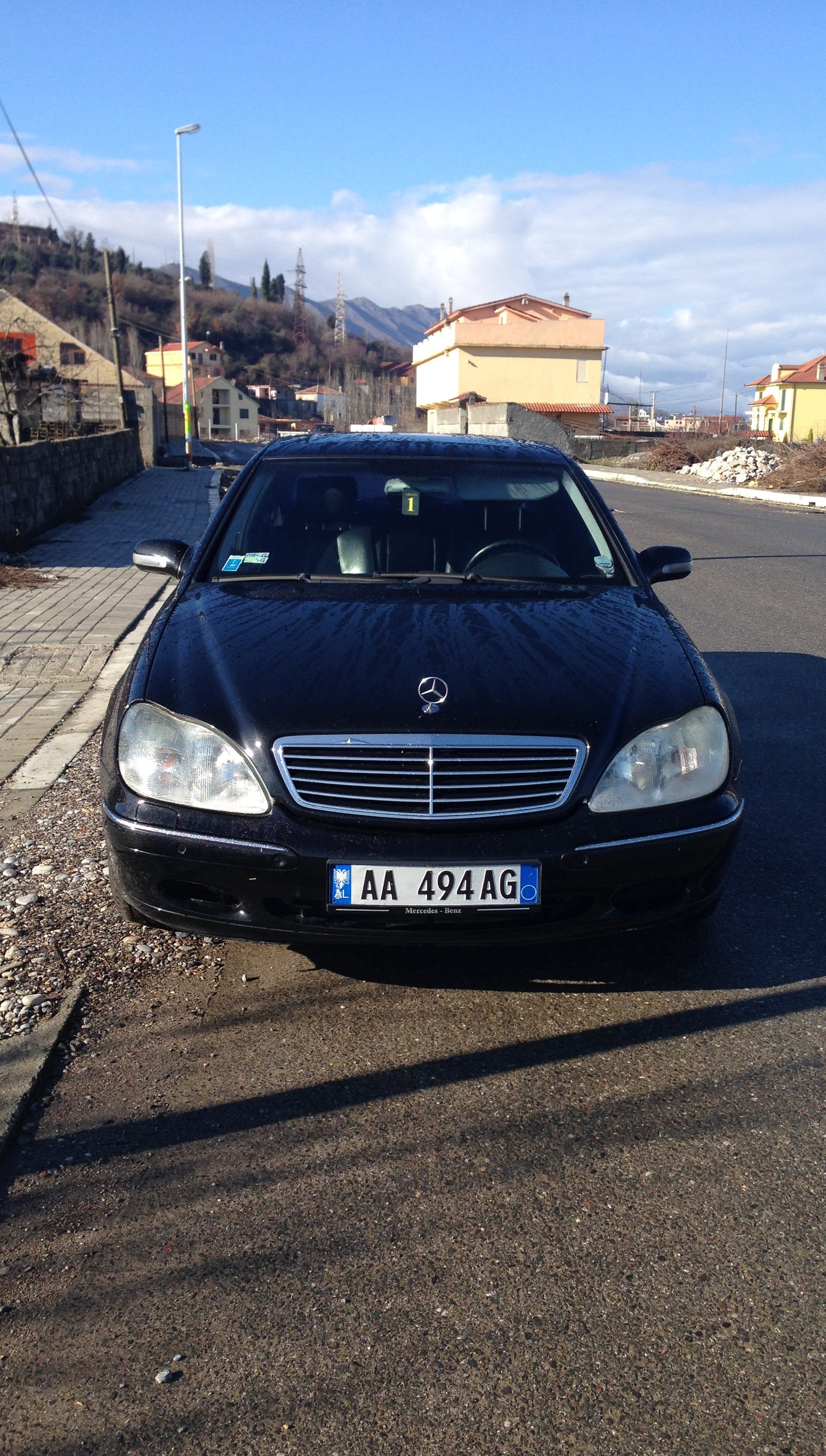 Arafed black car parked on the side of the road in front of a house (albania, benz, best, car, ever)