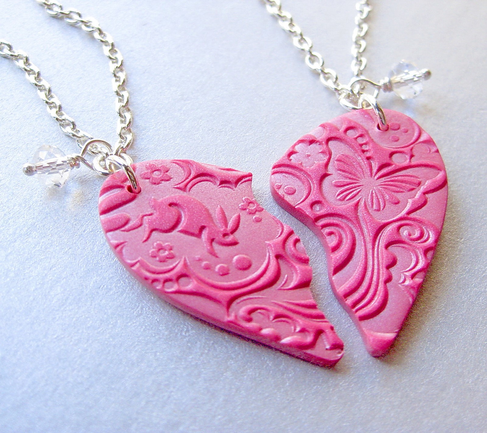 A close up of a pink heart shaped necklace with a chain (broken, heart, love, pendant, pink)