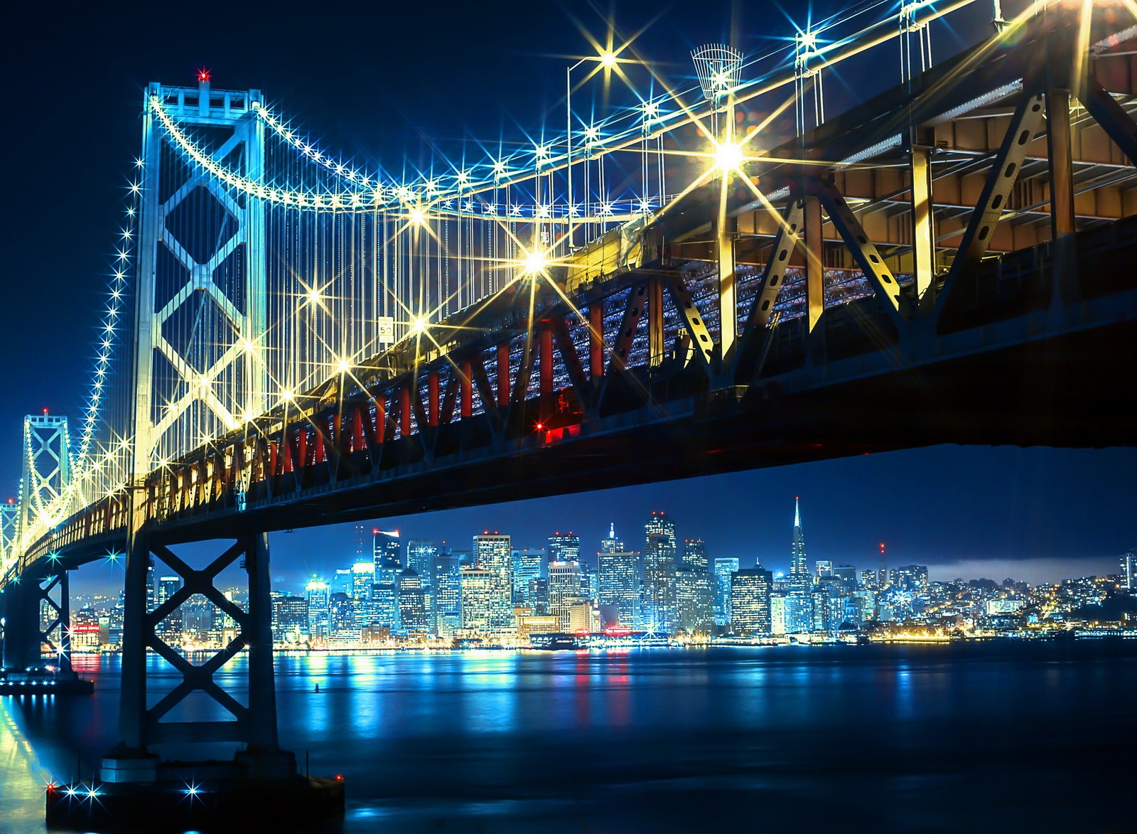 Vista de uma ponte sobre uma cidade à noite (baía, ponte, cidade, luzes, néon)