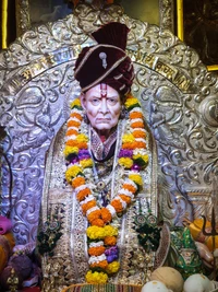 Presencia divina de Swami Samarth con decoración ornamentada y ofrendas florales