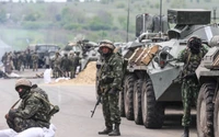 Soldados rusos en formación militar con vehículos blindados