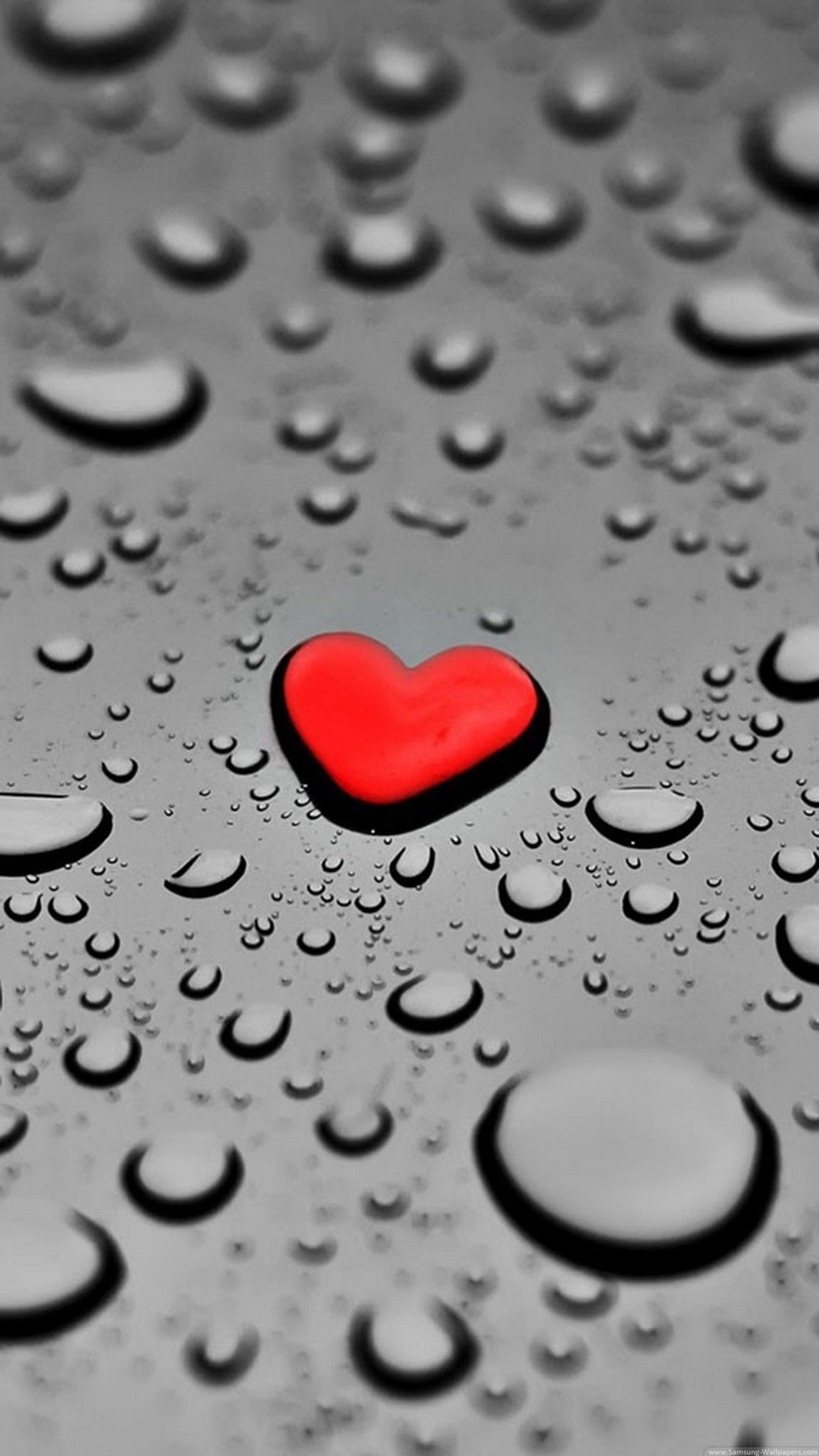 A close up of a red heart on a wet surface (drop, love, heart, red)