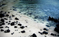 Tranquil Shoreline at Sunset with Rocks and Gentle Waves