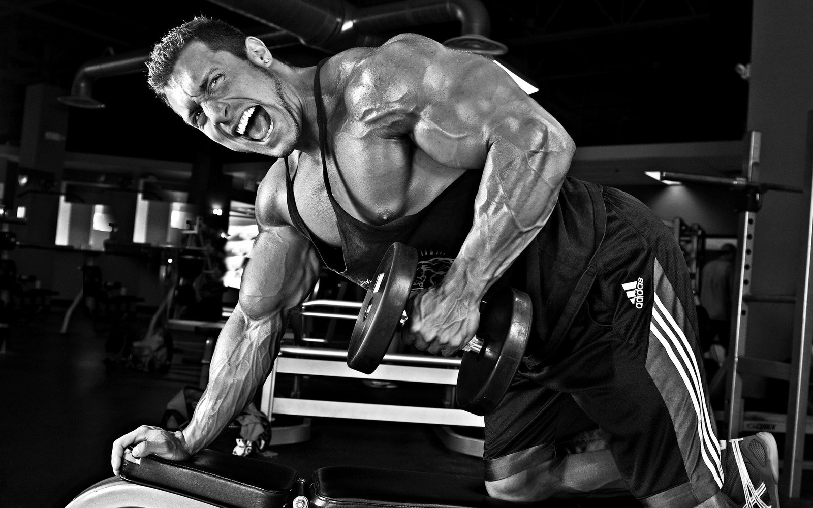 Hombre árabe en un gimnasio haciendo press de banca (culturismo, centro de fitness, músculo, aptitud física, entrenamiento de fuerza)