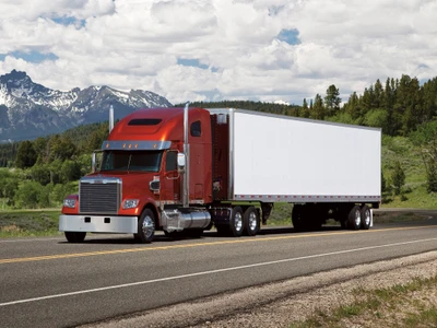 Camion semi-remorque Freightliner rouge sur une route pittoresque avec des montagnes en arrière-plan