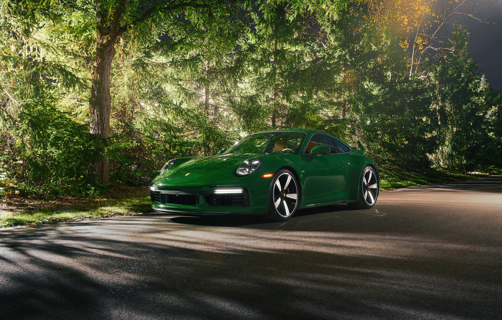 A close up of a green porsche parked on a road near trees (porsche 911 sport classic, 2023, cars, 4k wallpaper)