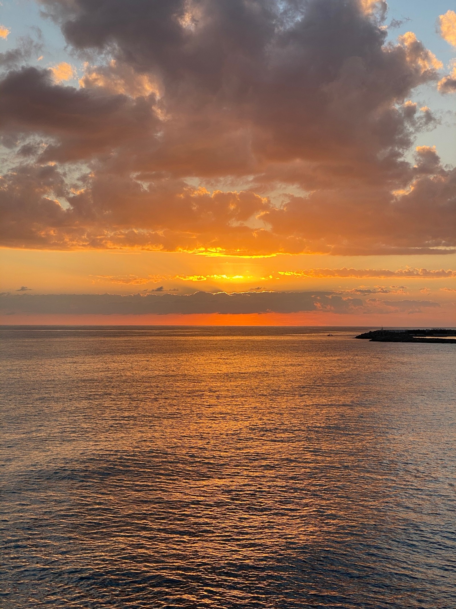 Vue aérienne d'un coucher de soleil sur l'océan avec un bateau dans l'eau (horizon, coucher de soleil, ensoleillement, nuage, eau)