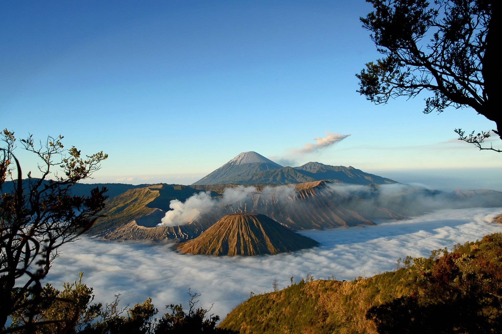 Vista aérea de uma montanha com um vale coberto de nuvens abaixo (montanha bromo, mount bromo, vulcão, montanha, formas montanhosas)