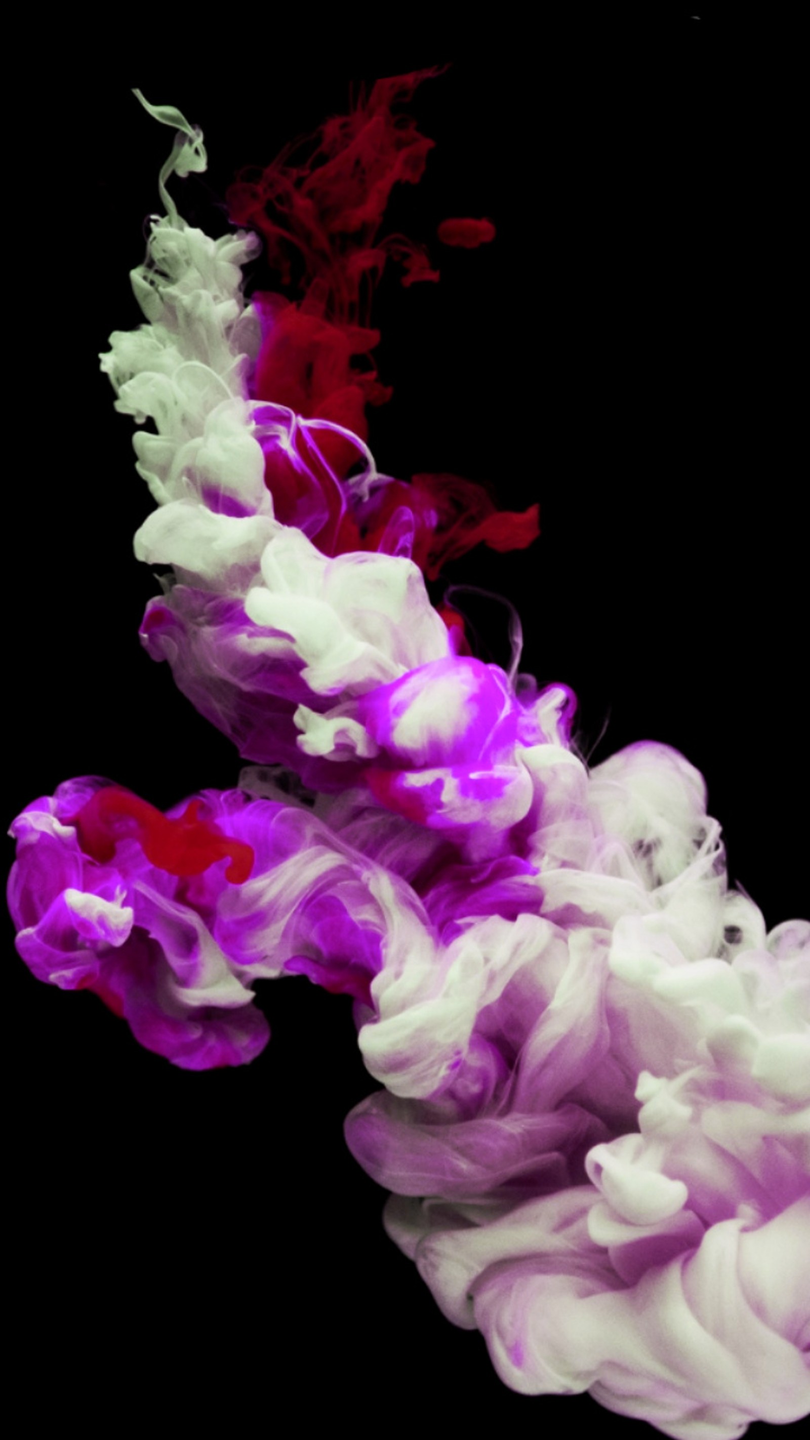 A close up of a red and white smoke is in the air (black, color, colored, colores, colorful)