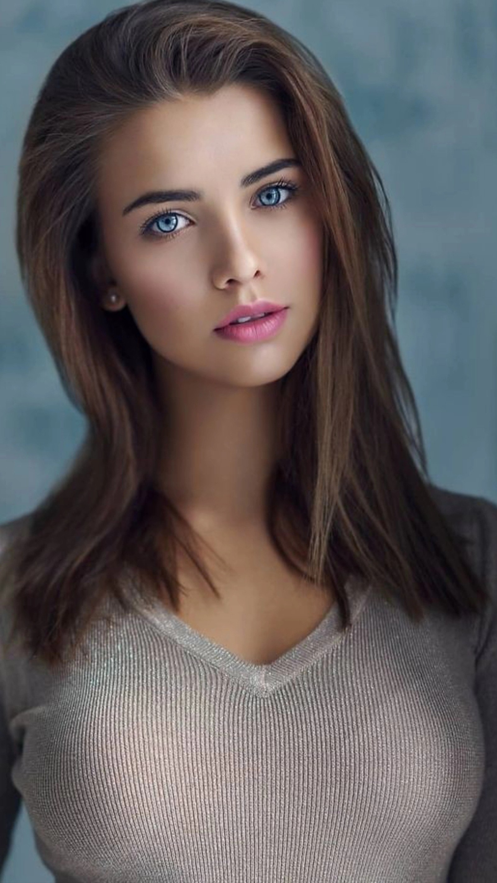 Une femme aux longs cheveux et aux yeux bleus pose pour une photo (beau, beauté, yeux bleus, cheveux bruns, charmant)