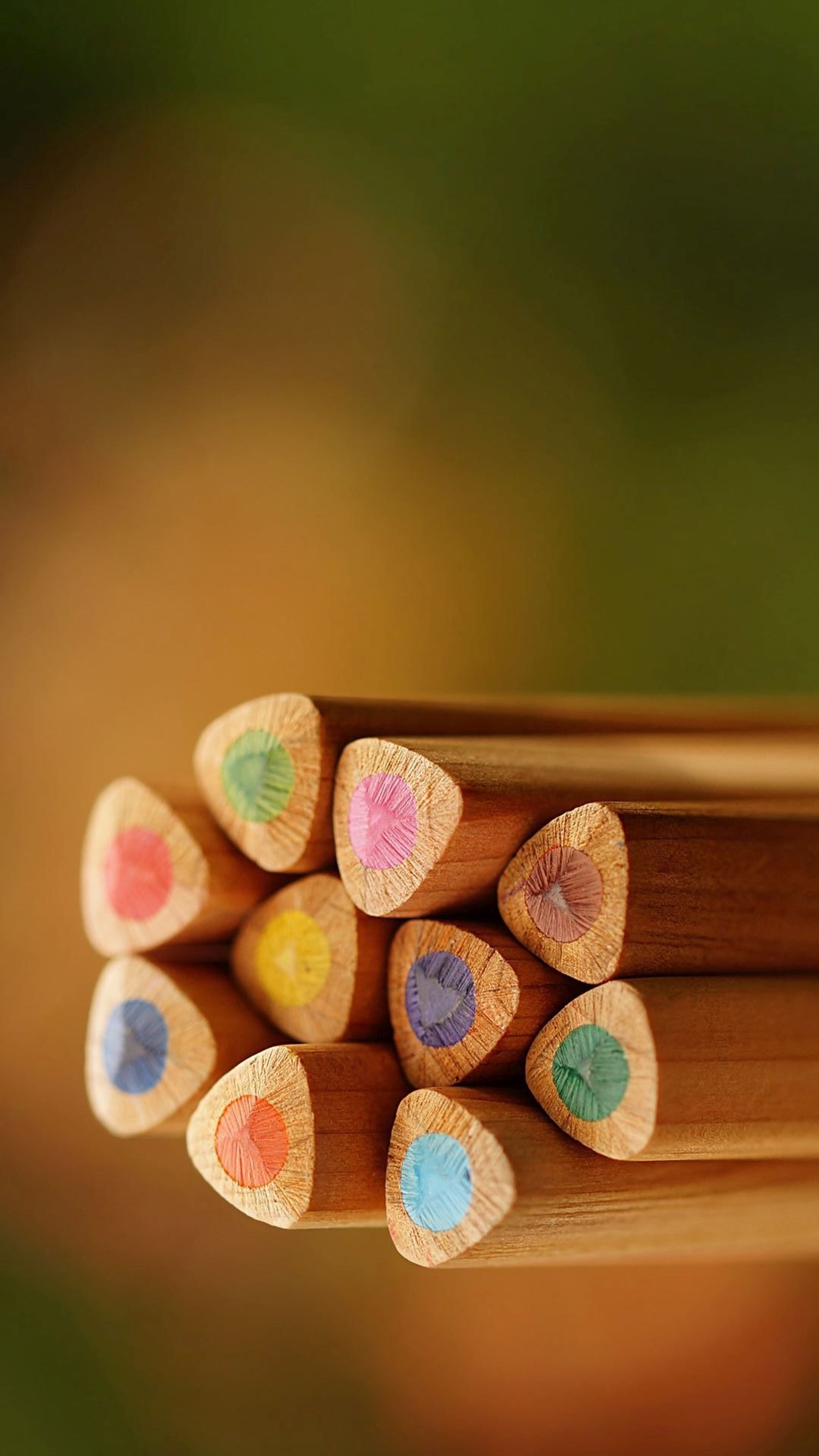 There are many colored pencils that are on top of a wooden table (artists choice, colored, pencils)