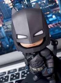 Figurine Chibi Batman contre un fond de paysage urbain