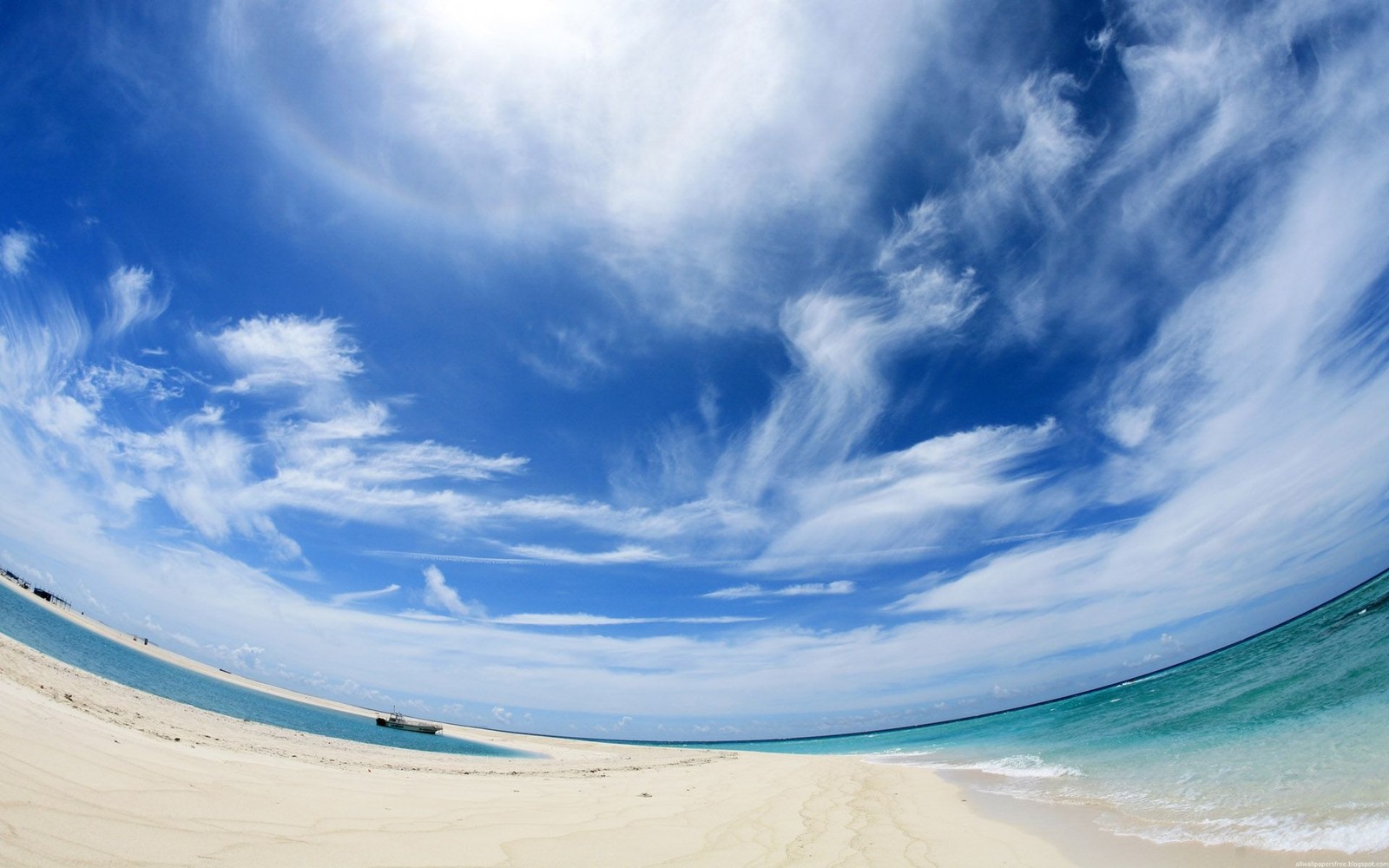 Vue arabe d'une plage avec un ciel bleu clair et quelques nuages (bleu, nuage, mer, vague, océan)