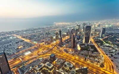 Luftaufnahme einer lebhaften Stadtlandschaft von Dubai mit ikonischen Wolkenkratzern und beleuchteten Autobahnen in der Dämmerung.