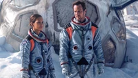 Astronauts in space suits stand together near a damaged spacecraft on a snowy landscape, emphasizing the tension and urgency of their mission in "Moonfall" (2022).