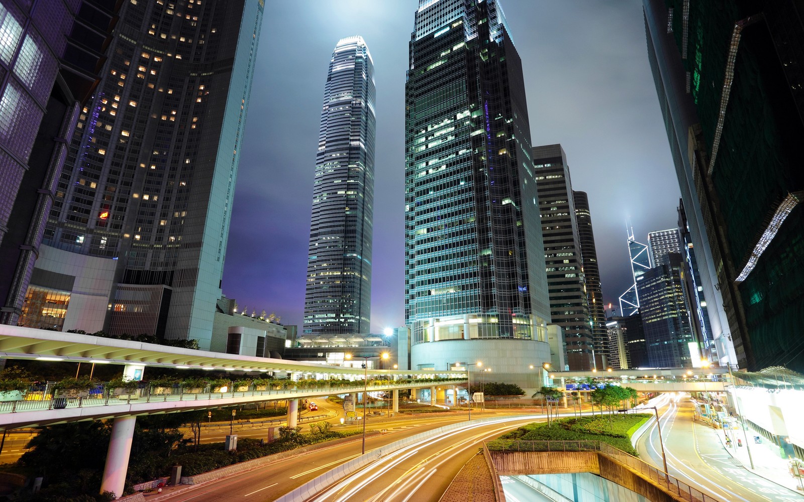 Uma vista de uma rua da cidade com muitos prédios altos (hong kong, noite, cidade, metrópole, paisagem urbana)