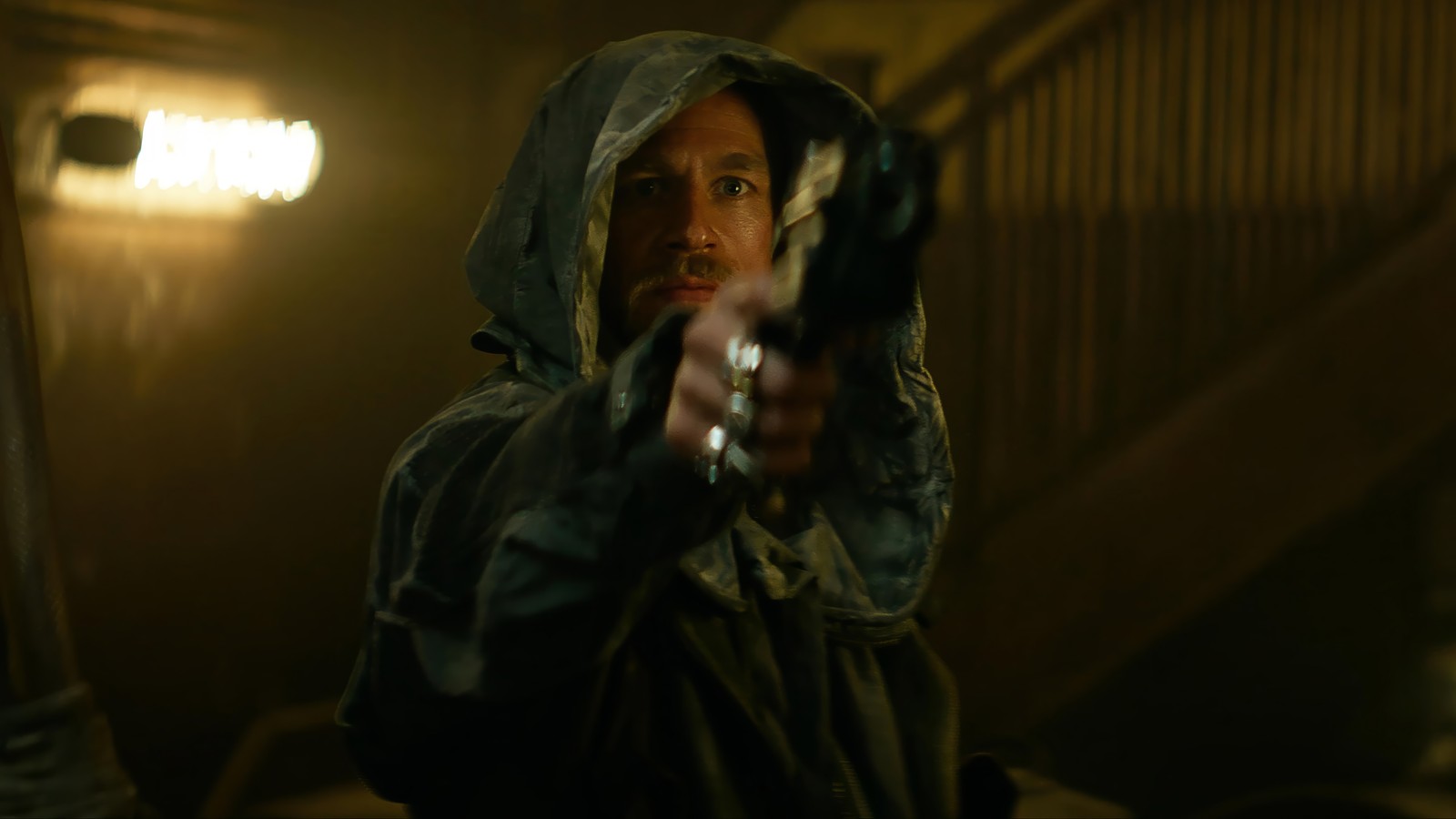 A man in a hoodedie pointing a gun at the camera (rebel moon, movie, kai, charlie hunnam)