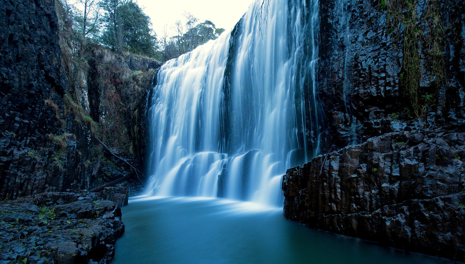 Una gran cascada cayendo por un acantilado rocoso estrecho (cascada, cuerpo de agua, recursos hídricos, naturaleza, agua)