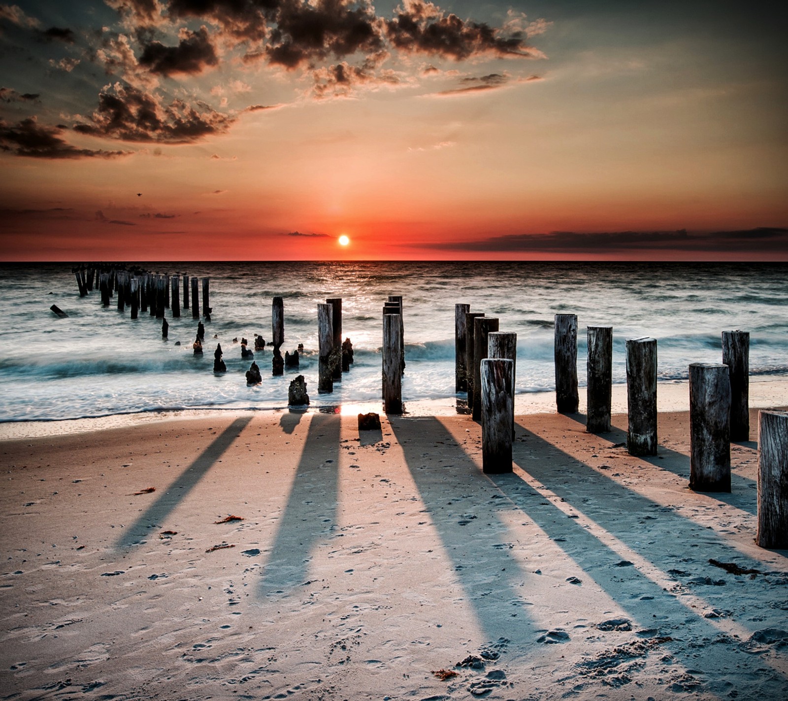 Vue aérienne d'une plage avec une jetée en bois et un coucher de soleil (été, coucher de soleil)