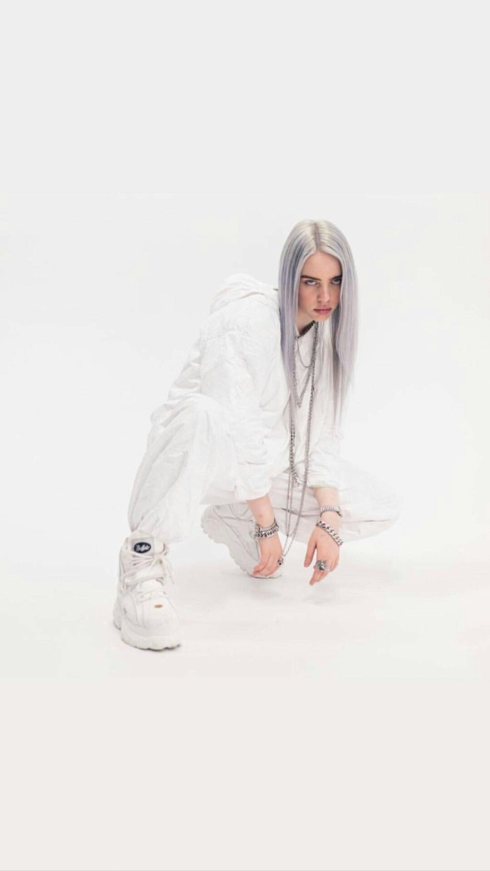 Eine arabische frau mit grauen haaren und einem weißen outfit, die sich hockt. (billie, eilish, weiß)