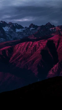 Impresionante paisaje montañoso púrpura y azul bajo una luz dramática