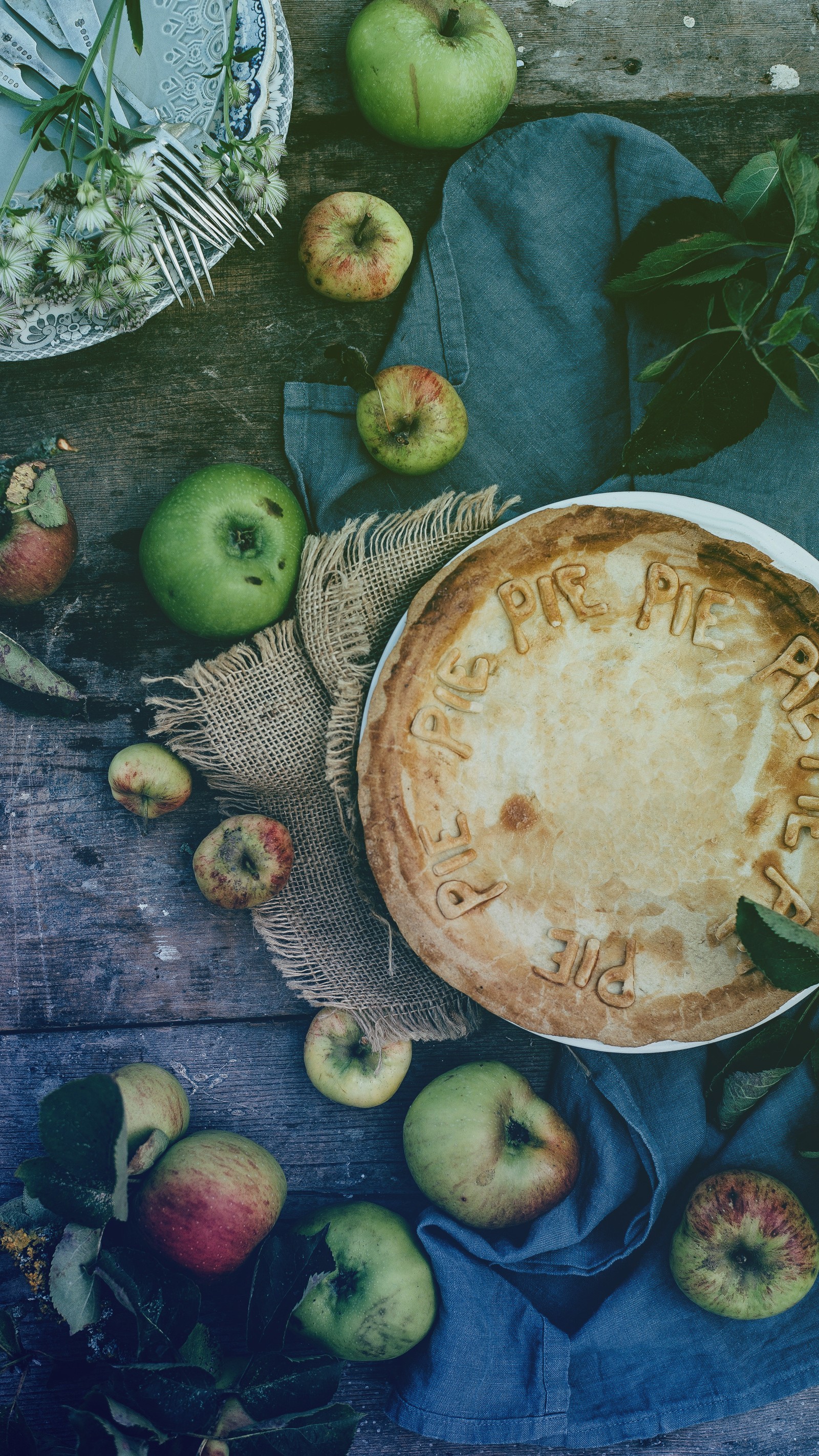 Uma torta com crosta em uma mesa com maçãs (ação de graças, comida, feriado, faminto, zedgethanks18)