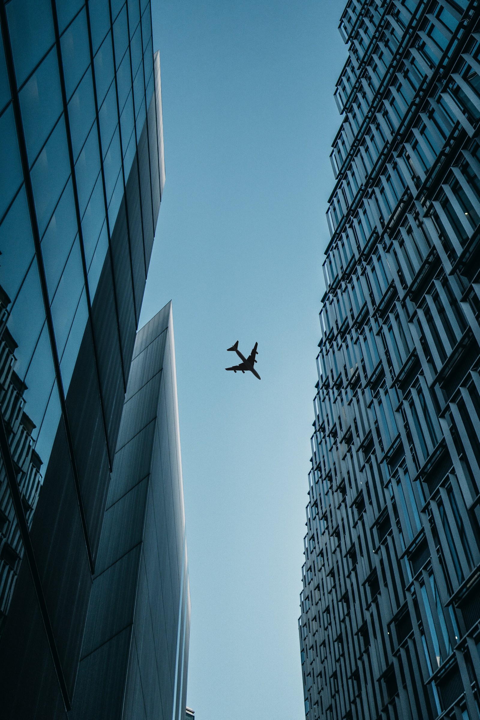 Araffle plane flying over a city with tall buildings (metropolis, tower block, bitcoin, daytime, high rise building)