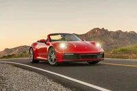 Porsche 911 Carrera Cabriolet 2020 sur une route de montagne pittoresque au coucher du soleil