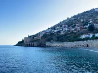 Kızılkule et terrain pittoresque au bord du lac sous un ciel azur