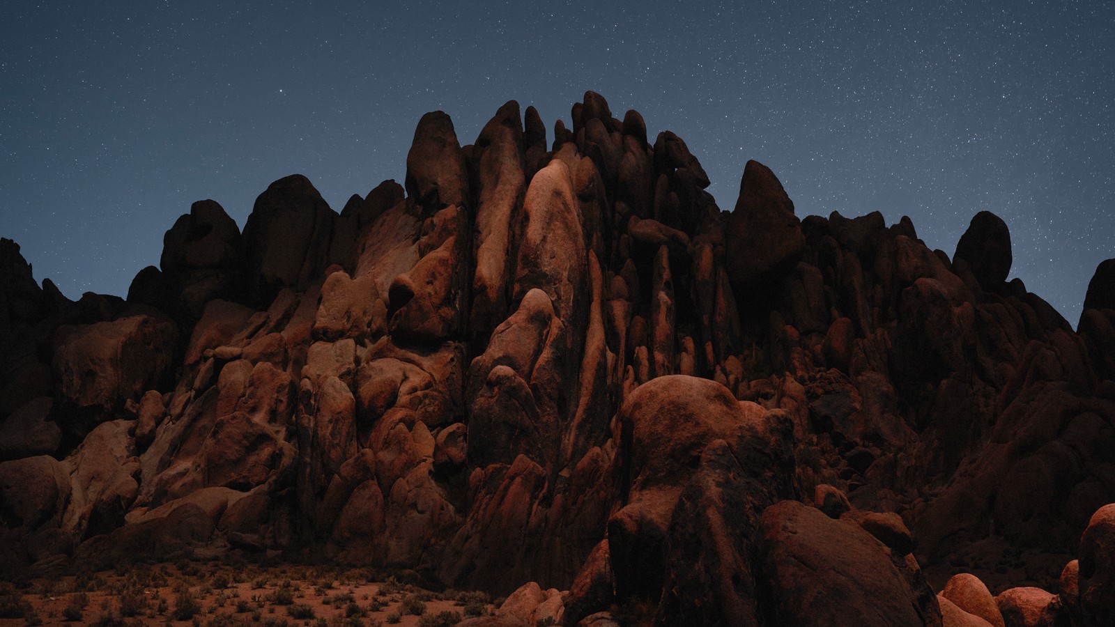 Une grande formation rocheuse avec un ciel étoilé en arrière-plan (désert, macos mojave, action, nuit, rochers)