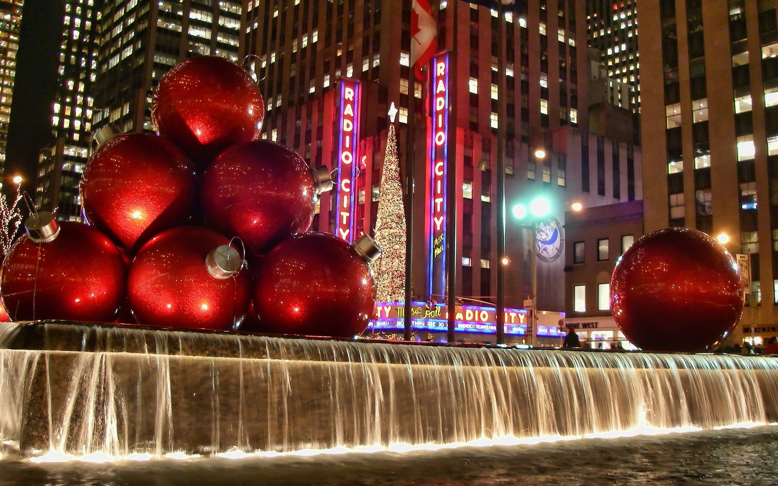 As bolas de natal decoradas estão colocadas em uma fonte na frente de um edifício (dia de natal, música de natal, água, edifício, arranha céus)