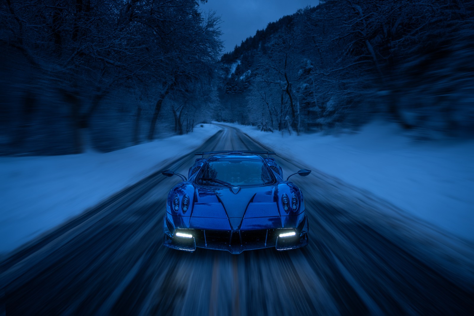 Eine nahaufnahme eines blauen sportwagens, der auf einer verschneiten straße fährt (pagani huayra roadster, schneebedeckt, straße, winterstraße, winterwald)