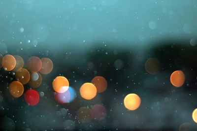 Weiches Bokeh von Regentropfen und Straßenlaternen an einem nebligen Abend