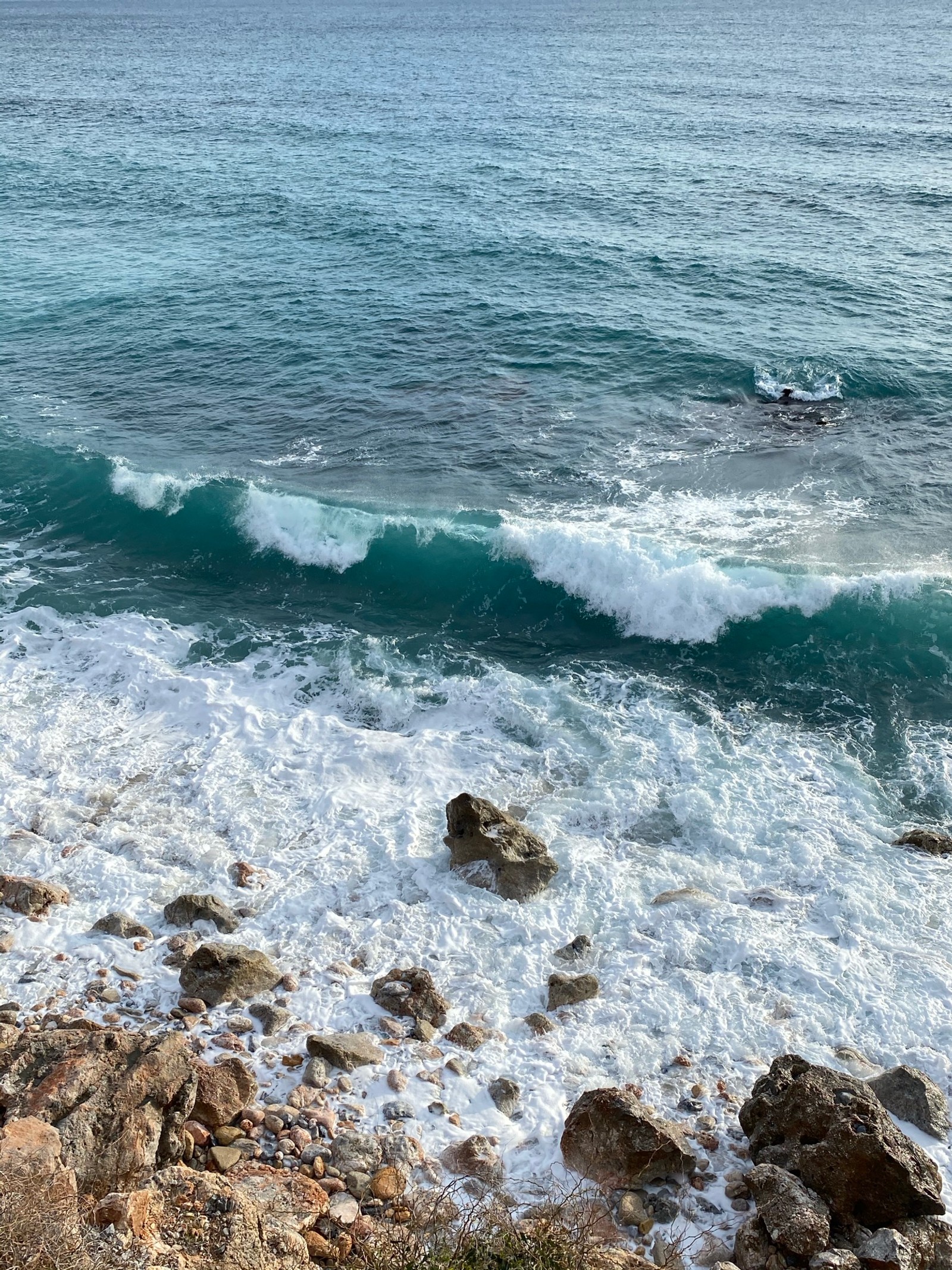 Los surfistas están montando las olas en la costa rocosa del océano (mar, física, ciencia, agua, recursos hídricos)