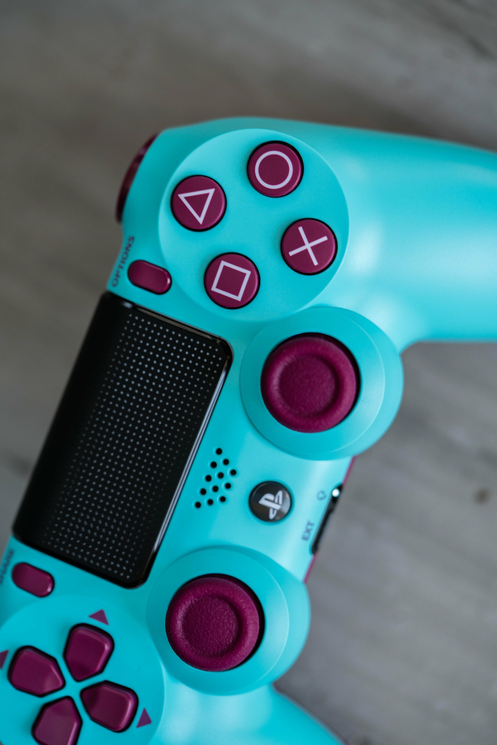 A close up of a blue video game controller with a red button (mando ps4 playstation, games, game, console, play)