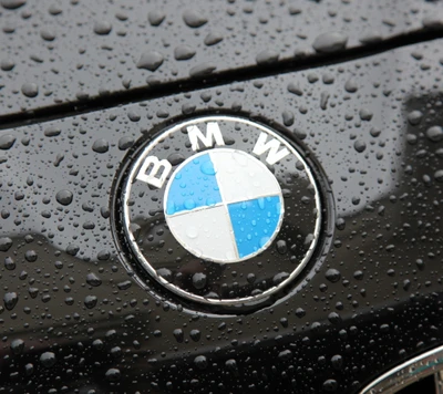 Emblème BMW avec des gouttes de pluie sur une surface noire