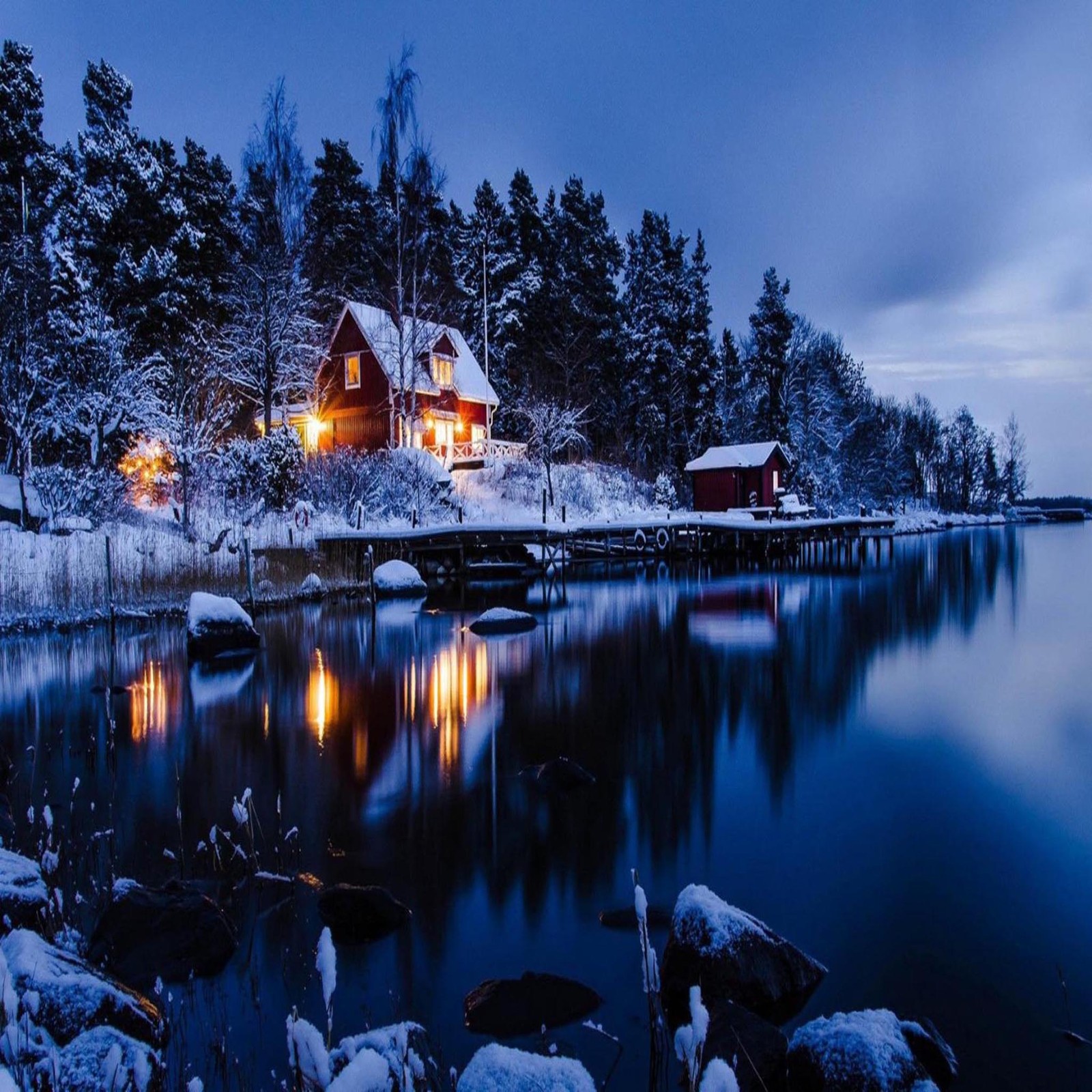 Une maison isolée sur un lac enneigé avec un quai et un hangar à bateaux (beau, mignon, regard, sympa)