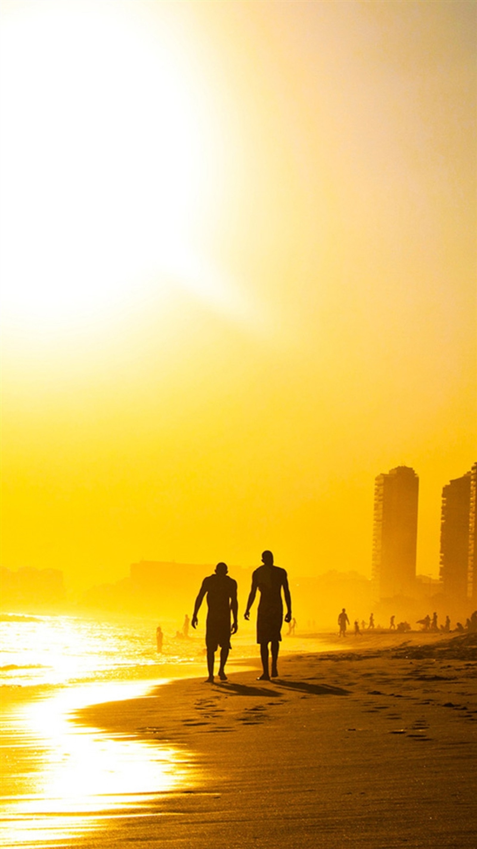 Surfer gehen am strand entlang, während die sonne untergeht. (strand, golden, sonnenuntergang)