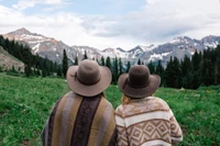 Natur erkunden: Freunde in Sonnenhüten umgeben von Berglandschaften