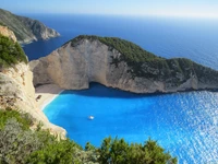 Vista de tirar o fôlego da Praia de Navagio, Zakynthos, mostrando penhascos íngremes e as vibrantes águas azuis do Mar Jônico.