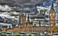 Das Parlament und Big Ben, die über die Themse unter einem dramatischen Himmel blicken.