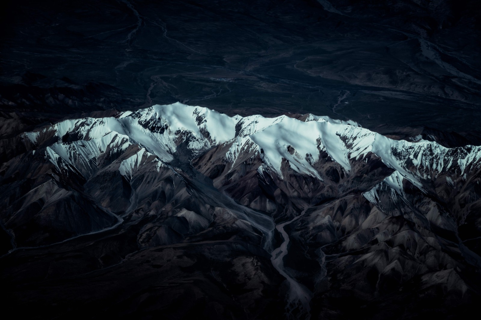 Vue d'une chaîne de montagnes avec une rivière qui la traverse (forme glaciaire, terre, obscurité, formation terrestre, nature)