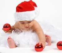 Fröhliches Baby in einem Weihnachtsmannhut, umgeben von Weihnachtsornamenten