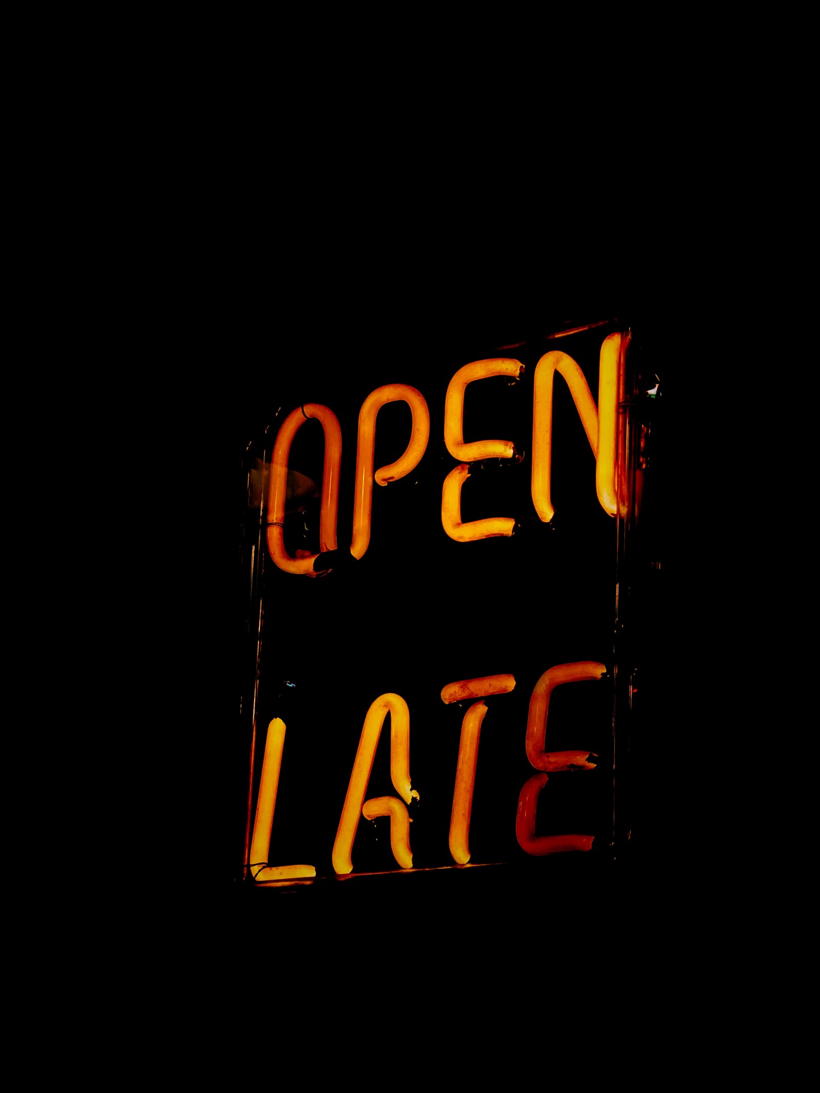 Neon sign of open late on a dark street at night (orange, neon sign, text, signage, electronic signage)