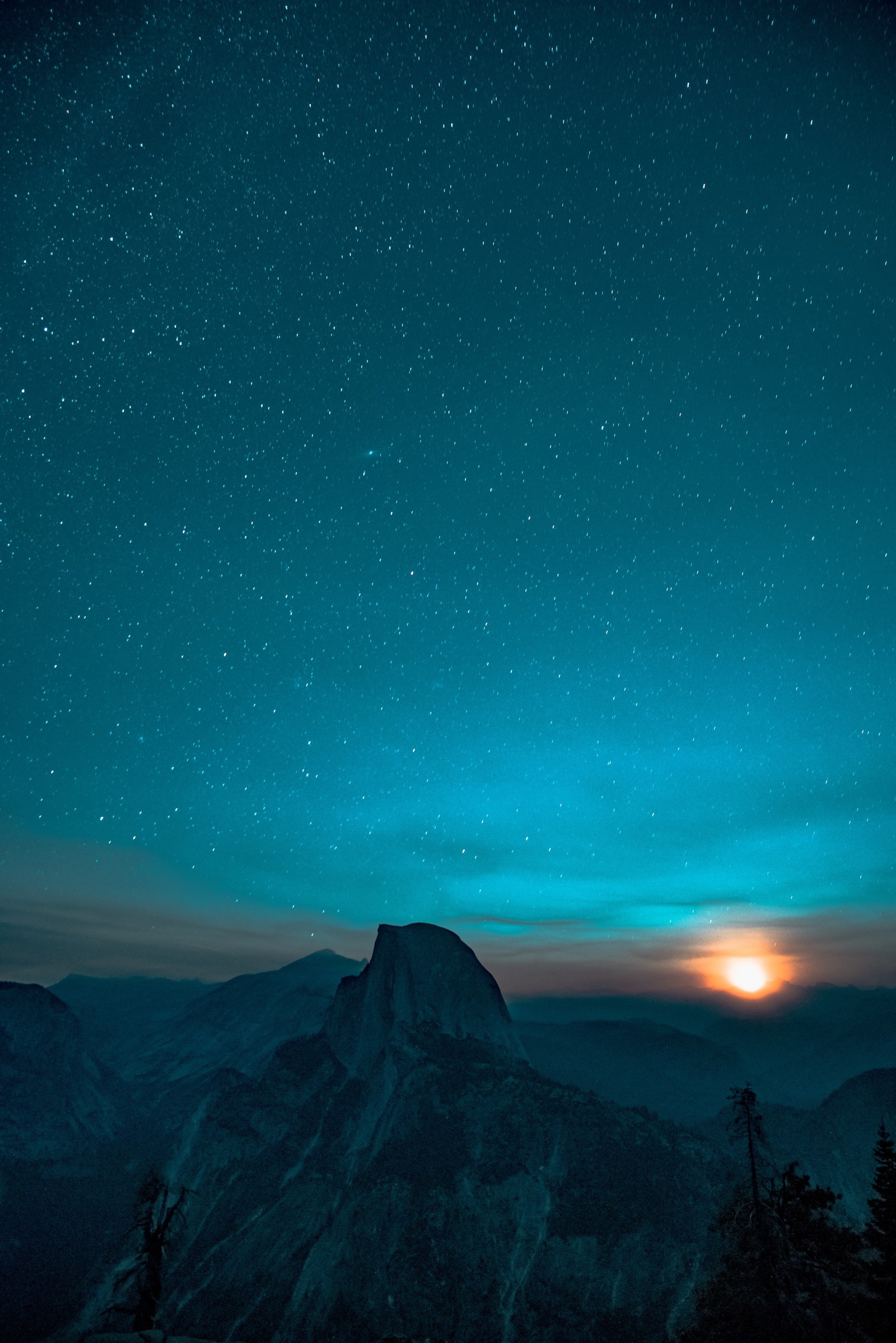 Cielo estrellado sobre una montaña con una luna llena y una luz naranja brillante (galaxia, mac, montaña, nebulosa, noche)