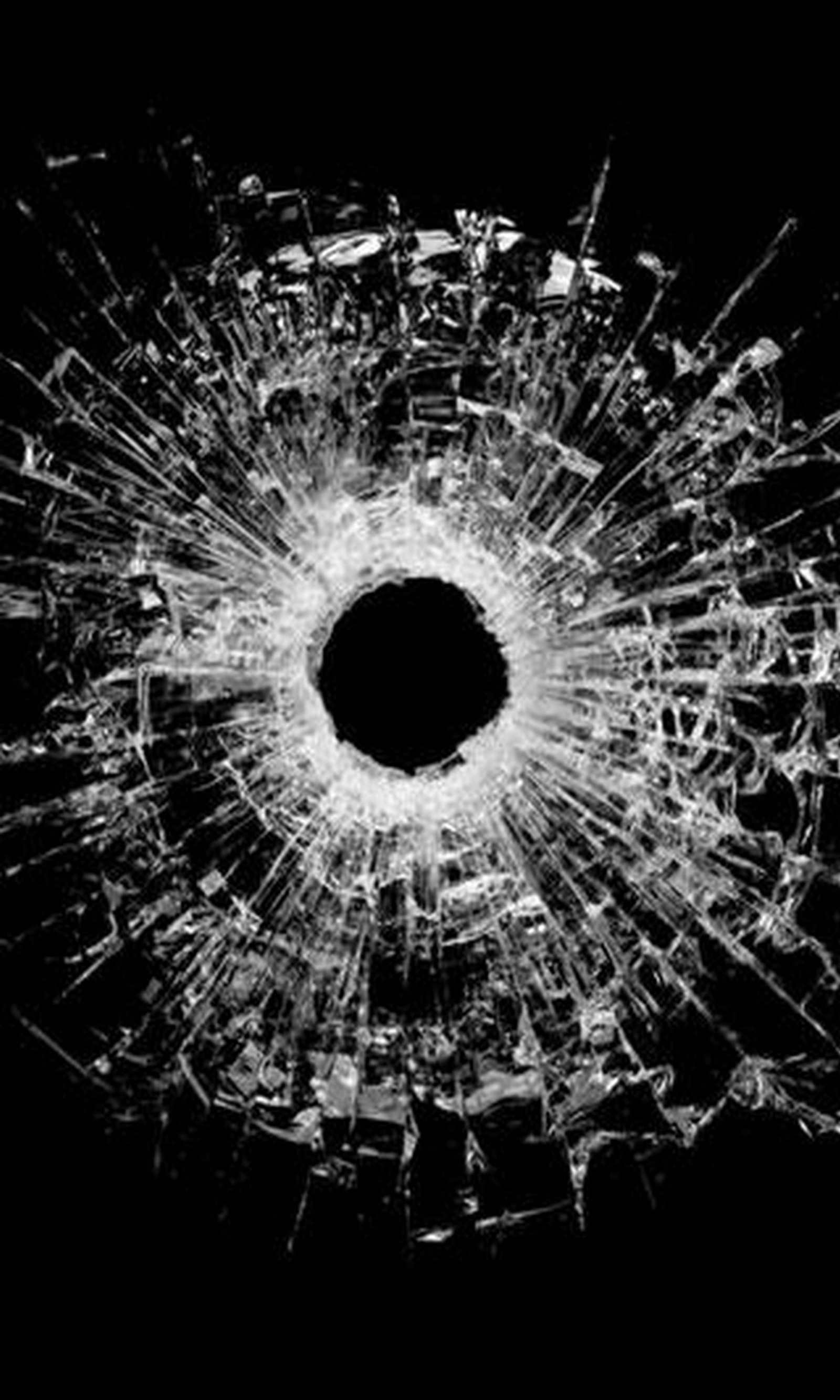 A bullet hole in a glass with a black background (bullet, bullet hole, cracked, fun, hole)