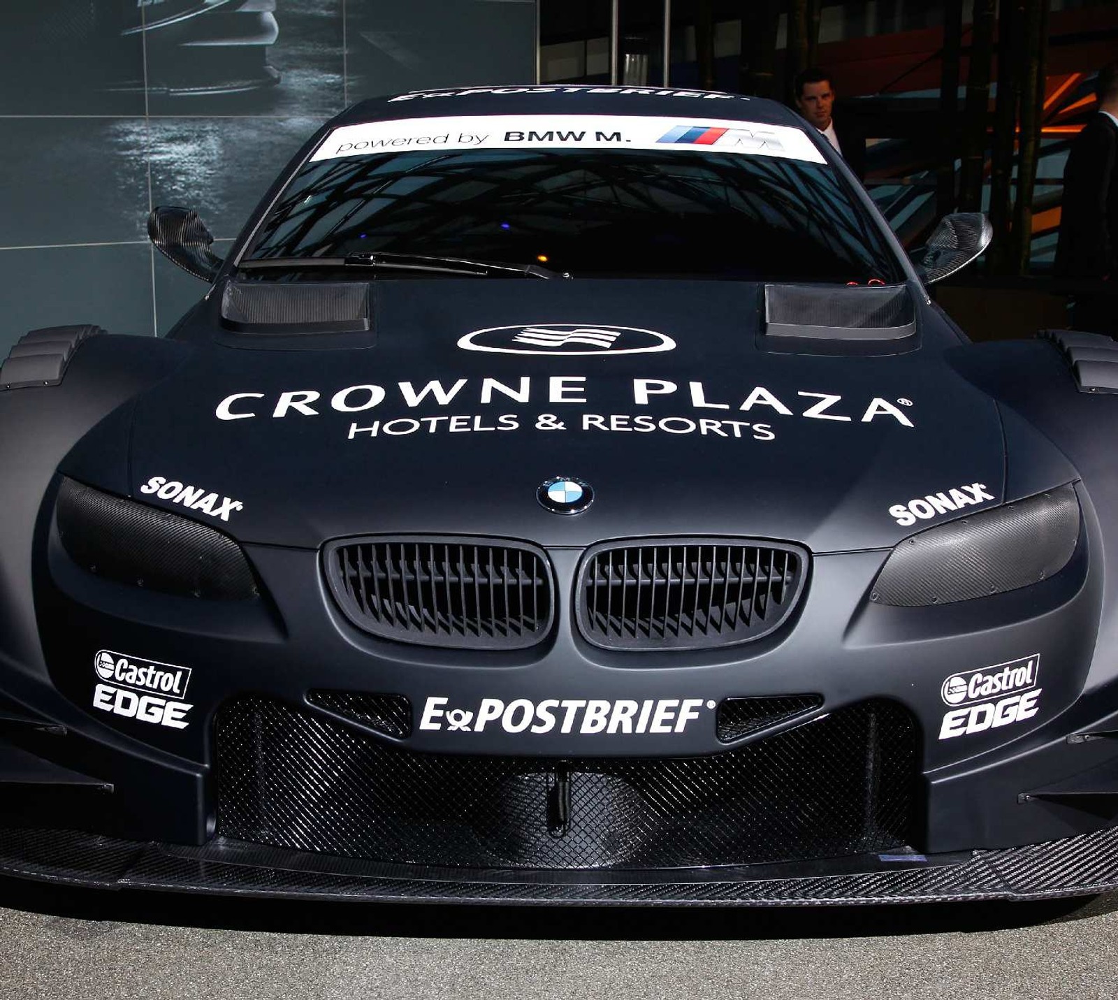 Arafed bmw race car with crowne plaza hotel and resort logo (bmw, dtm)